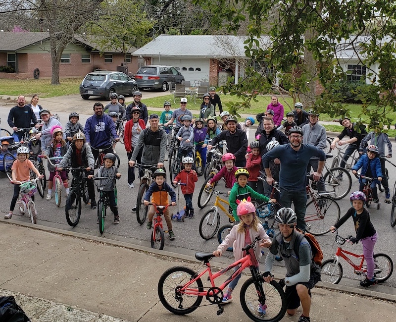 Large group of elementary school aged cyclists and adults on Bike to School Day.