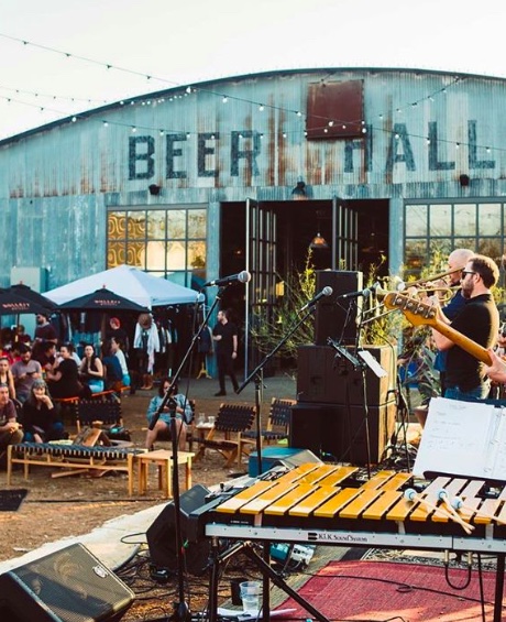 People enjoying a band in the beer garden at Central Mill Works in Austin.