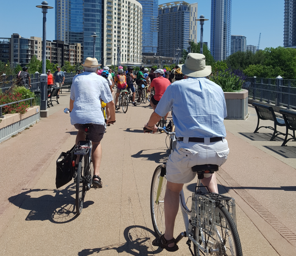 Group of cyclists riding across the Pfluger Pedestrian Bridge in Austin.